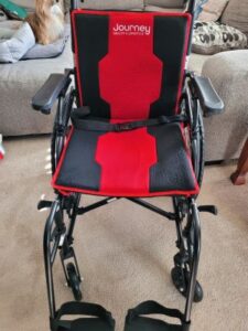 The chair is red and black with minor damage on the seat pad.